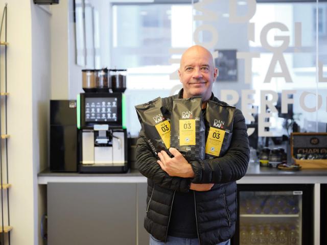 Billede af Steen, der står med kaffeposer i hænderne foran kaffemaskinerne ved No Zebra